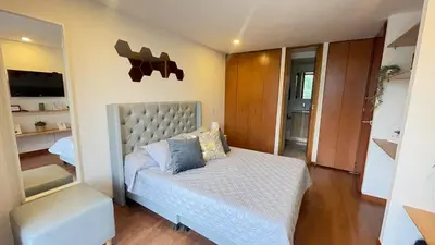 a bedroom with a bed and a chair and a television at Aparta estudio muy bien ubicado in Medellín