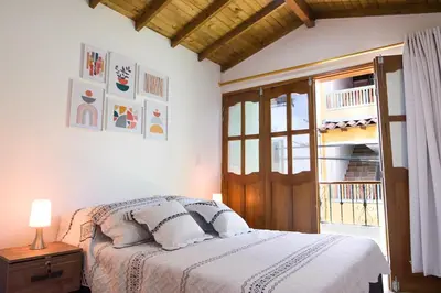 a bedroom with a bed and a wooden door at Beautiful Modern House in Guatape! in Guatapé
