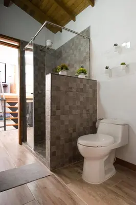 a bathroom with a toilet and a glass shower at Beautiful Modern House in Guatape! in Guatapé