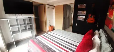 a bedroom with a bed and a guitar on the wall at Stylish Loft in Laureles-Gorgeous views & comfort in Medellín
