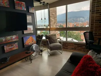 a living room with a couch and a large window at Stylish Loft in Laureles-Gorgeous views & comfort in Medellín