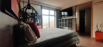 a bedroom with a bed and a large window at Stylish Loft in Laureles-Gorgeous views & comfort in Medellín