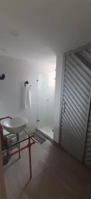 a bathroom with a white sink and a sliding door at Stylish Loft in Laureles-Gorgeous views & comfort in Medellín