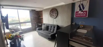 a living room with a couch and a table at Stylish Loft in Laureles-Gorgeous views & comfort in Medellín