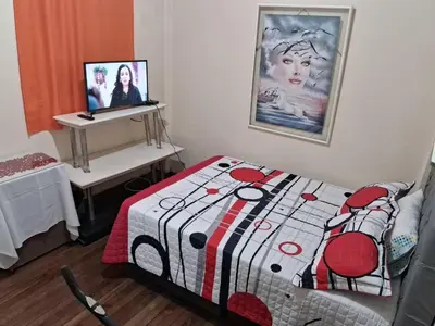 a bedroom with a bed and a desk with a picture on the wall at Hospedaje Parque Caldas Fundadores Manizales in Manizales
