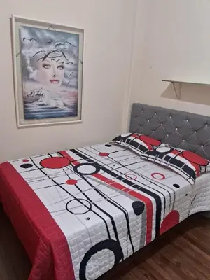 a bed with a quilt on it in a bedroom at Hospedaje Parque Caldas Fundadores Manizales in Manizales