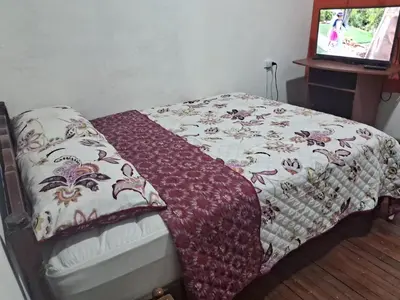 a bed with a blanket on it in a room at Hospedaje Parque Caldas Fundadores Manizales in Manizales