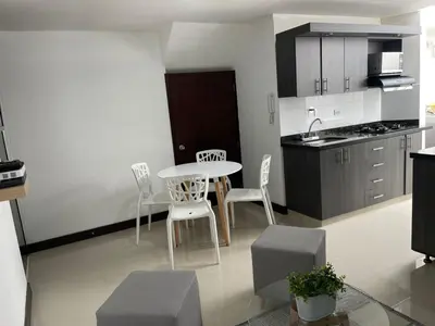 a kitchen and dining room with a table and chairs at Apartamento familiar laureles 203 in Medellín
