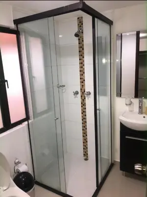 a bathroom with a glass shower and a sink at Apartamento familiar laureles 203 in Medellín