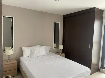 a bedroom with a large bed with white sheets and pillows at Apartamento familiar laureles 203 in Medellín