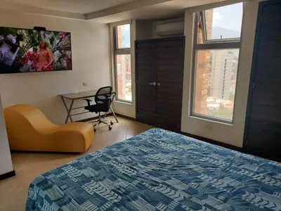a bedroom with a bed and a desk and a chair at Penthouse Rooftop terrace Gem in the sky-Laureles in Medellín