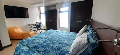 a bedroom with a bed with a blue comforter at Penthouse Rooftop terrace Gem in the sky-Laureles in Medellín