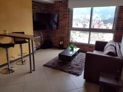 a living room with a couch and a flat screen tv at Penthouse Rooftop terrace Gem in the sky-Laureles in Medellín