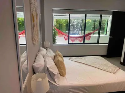 a bedroom with a large bed with a window at Apartamento con balcón y hamaca en zona rosa laureles 301 in Medellín