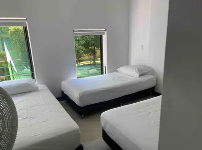 a room with three beds and two windows at Apartamento con balcón y hamaca en zona rosa laureles 301 in Medellín