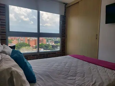 a bedroom with a bed and a large window at Best views in town, 14th floor Laureles Gem in Medellín