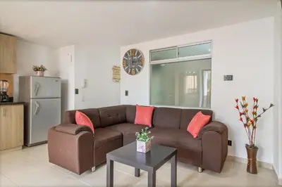 a living room with a brown couch and a table at Hermoso apartamento en el centro in Medellín