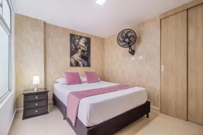 a bedroom with a bed and a clock on the wall at Hermoso apartamento en el centro in Medellín