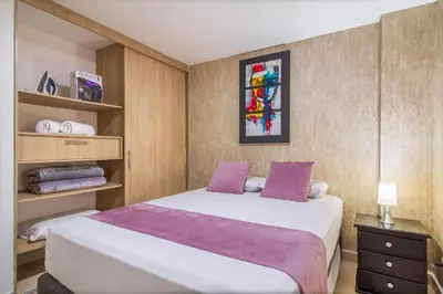 a bedroom with a large white bed with purple sheets at Hermoso apartamento en el centro in Medellín