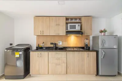 a kitchen with wooden cabinets and a stainless steel refrigerator at Hermoso apartamento en el centro in Medellín