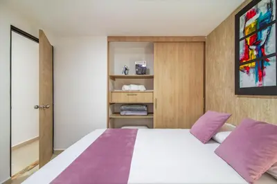 a bedroom with a large bed with purple pillows at Hermoso apartamento en el centro in Medellín