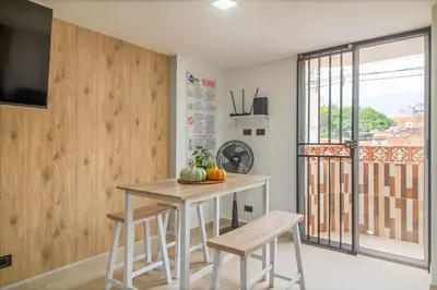 a kitchen with a table and chairs and a balcony at Hermoso apartamento en el centro in Medellín