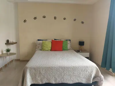 a bedroom with a bed with four colorful pillows at Lovely one bedroom condo in beautiful Laureles in Medellín