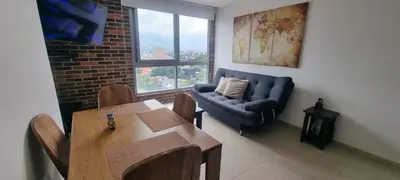 a living room with a couch and a table at Laureles Deluxe Apartment in the Medellin sky in Medellín