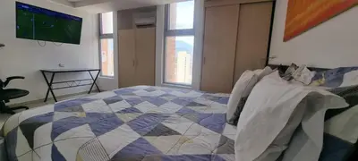 a bedroom with a bed and a tv on the wall at Laureles Deluxe Apartment in the Medellin sky in Medellín