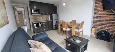 a living room with a blue couch and a table at Laureles Deluxe Apartment in the Medellin sky in Medellín