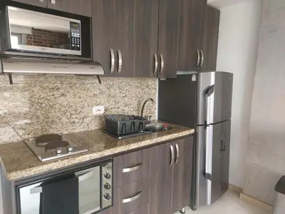 a kitchen with a stainless steel refrigerator and a microwave at Laureles Deluxe Apartment in the Medellin sky in Medellín