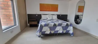a bedroom with a bed with a blue and white comforter at Laureles Deluxe Apartment in the Medellin sky in Medellín