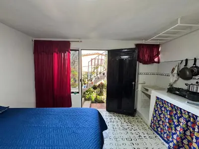 a bedroom with a blue bed and red curtains at Aparta estudio comuna trece in Medellín