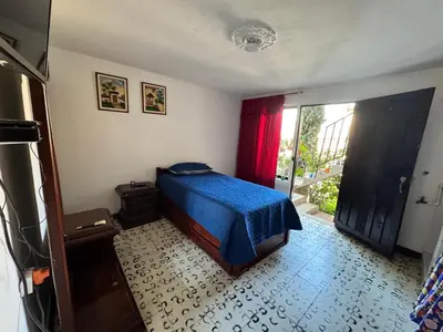 a bedroom with a bed with a blue blanket and a window at Aparta estudio comuna trece in Medellín