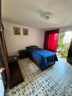 a bedroom with a blue bed and a red curtain at Aparta estudio comuna trece in Medellín