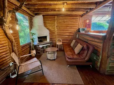 a living room with a couch and a fireplace at Forest Cabin Nature Retreat in Rionegro