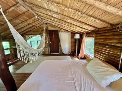 a bed in a room with a hammock at Forest Cabin Nature Retreat in Rionegro