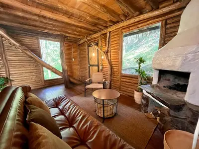 a living room with a couch and a fireplace at Forest Cabin Nature Retreat in Rionegro