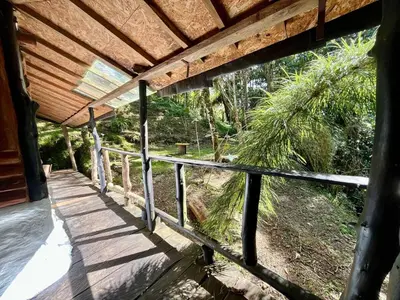 a porch of a house with a wooden roof at Forest Cabin Nature Retreat in Rionegro