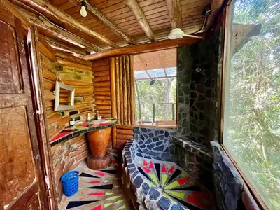 a room with a bench in a log cabin at Forest Cabin Nature Retreat in Rionegro