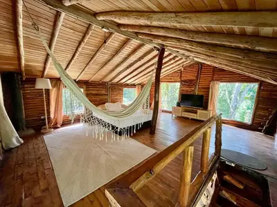 a hammock in a room in a log cabin at Forest Cabin Nature Retreat in Rionegro