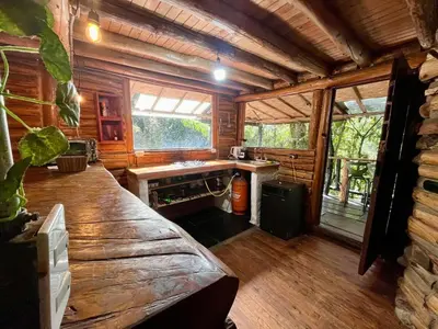 a log cabin with a bench in a room at Forest Cabin Nature Retreat in Rionegro