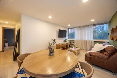 a living room with a wooden table and a couch at Cómodo y recién remodelado apto de 2 habitaciones cerca a Provenza in Medellín