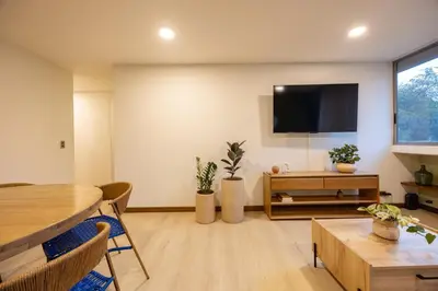 a living room with a table and a flat screen tv at Cómodo y recién remodelado apto de 2 habitaciones cerca a Provenza in Medellín