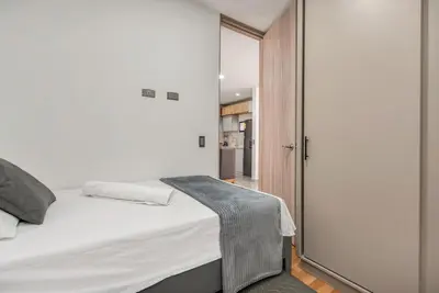 a bedroom with a white bed and a sliding glass door at Espectacular apartamento en Itagui in Itagüí