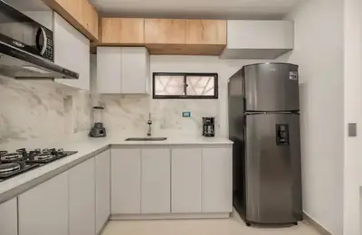 a kitchen with white cabinets and a stainless steel refrigerator at Espectacular apartamento en Itagui in Itagüí