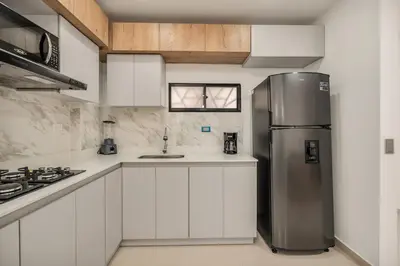 a kitchen with white cabinets and a stainless steel refrigerator at Espectacular apartamento en Itagui in Itagüí