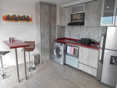 a kitchen with a stove and a washing machine at Laureles 16th floor stylish Spring City Treat in Medellín