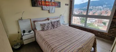 a bedroom with a bed and a large window at Laureles 16th floor stylish Spring City Treat in Medellín