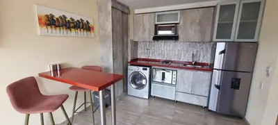 a small kitchen with a refrigerator and a washing machine at Laureles 16th floor stylish Spring City Treat in Medellín